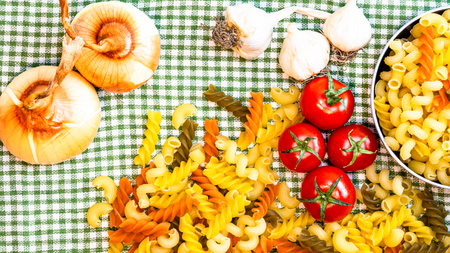 Beautiful tasty Italian pasta, tomatoes, onions and garlic for cooking pastaの写真素材