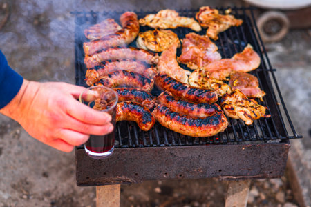 Grilling sausages and pork chops on barbecue grill. BBQ in the gardenの写真素材