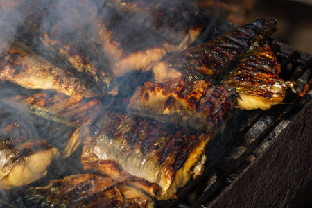 Grilled mackerel fish with smoke on a charcoal barbecue grill.の写真素材