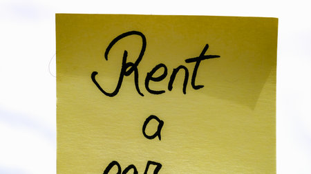 Rent car handwriting text close up isolated on yellow paper with copy space.の写真素材