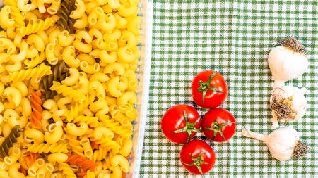 Beautiful tasty Italian pasta, tomatoes, onions and garlic for cooking pastaの写真素材