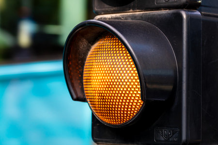 Part of a traffic light, with yellow light turned onの写真素材