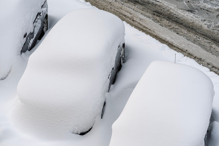 Snow on cars after snowfall. Winter urban scene and snow-covered carsの写真素材