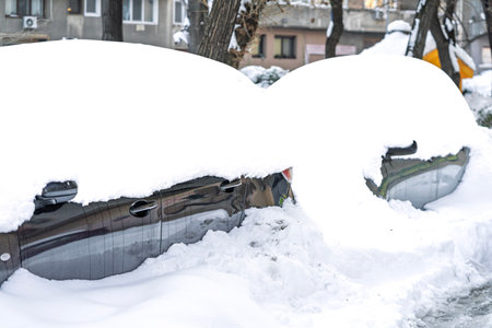 Snow on cars after snowfall. Winter urban scene and snow-covered carsの写真素材