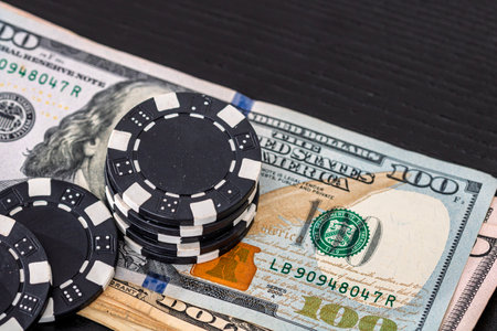 Stacks of poker chips with money on black background, US Dollar currencyの写真素材
