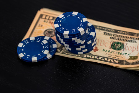 Stacks of poker chips with money on black background, US Dollar currencyの写真素材