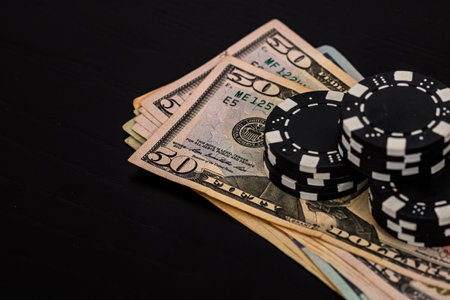 Stacks of poker chips with money on black background, US Dollar currencyの写真素材