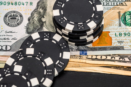 Stacks of poker chips with money on black background, US Dollar currency