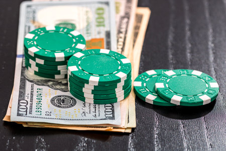 Stacks of poker chips with money on black background, US Dollar currencyの写真素材