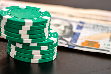 Stacks of poker chips with money on black background, US Dollar currencyの写真素材