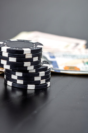 Stacks of poker chips with money on black background, US Dollar currencyの写真素材