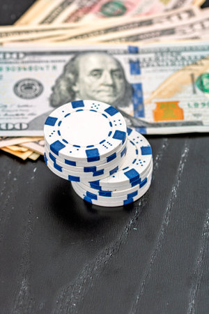 Stacks of poker chips with money on black background, US Dollar currencyの写真素材