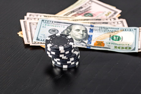Stacks of poker chips with money on black background, US Dollar currencyの写真素材