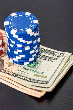 Stacks of poker chips with money on black background, US Dollar currencyの写真素材