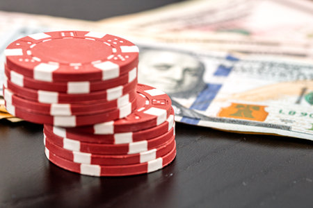 Stacks of poker chips with money on black background, US Dollar currencyの写真素材