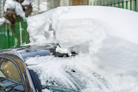 Snow on cars after snowfall. Winter urban scene and snow-covered carsの写真素材