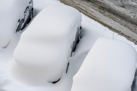 Snow on cars after snowfall. Winter urban scene and snow-covered carsの写真素材