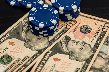 Stacks of poker chips with money on black background, US Dollar currency