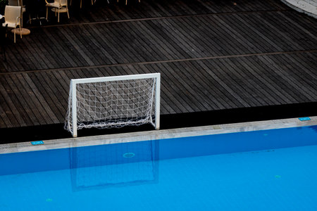 Clean swimming pool with clear blue water, bordered by white tiles and a striped deck, capturing the essence of a refreshing day at the poolの写真素材