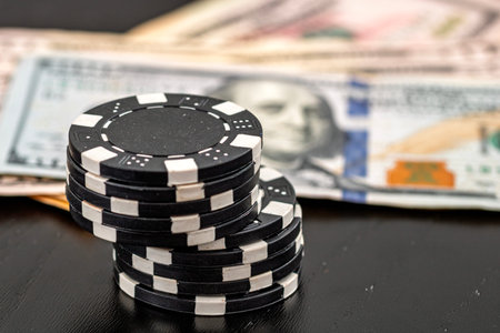 Stacks of poker chips with money on black background, US Dollar currency