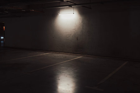 Empty underground garage. Empty parking lot with overhead dim lightの写真素材