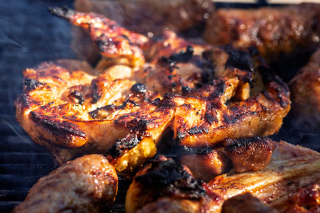 Pork chops, steak, sausages on barbecue grill with smoke