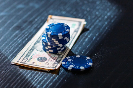 Stacks of poker chips with money on black background, US Dollar currencyの写真素材