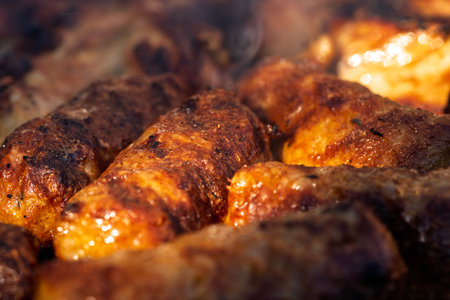Pork chops, steak, sausages on barbecue grill with smoke