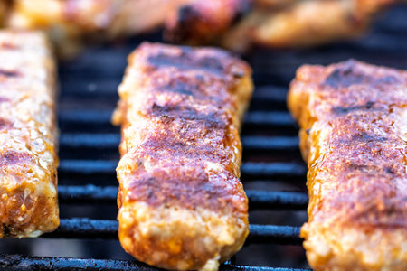 Pork chops, steak, sausages on barbecue grill with smoke