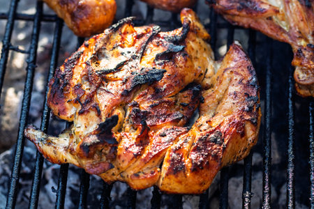 Pork chops, steak, sausages on barbecue grill with smokeの写真素材