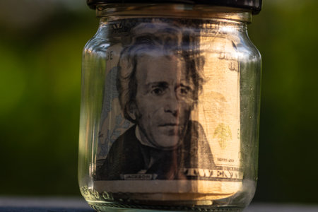 US dollar banknote saving money in glass jar. Consumption and economy. Business, tips, finance, saving, banking and people conceptの写真素材