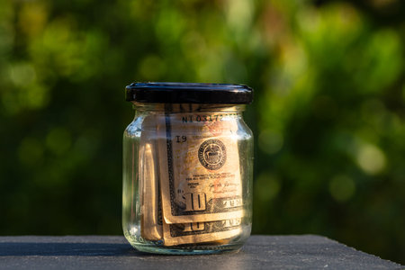 US dollar banknote saving money in glass jar. Consumption and economy. Business, tips, finance,...