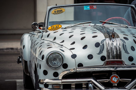 Vintage classic American car in Havana, Cuba. Typical Havana urban scene with colorful buildings and...