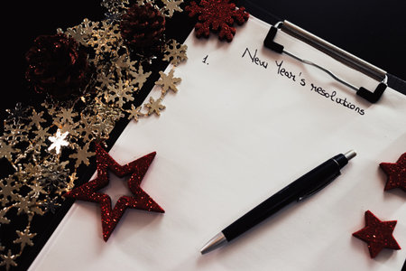 Writing New Year`s Resolutions for Christmas. Christmas Resolutions. Text New Year`s Resolutions on paper.の写真素材