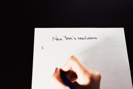 Writing New Year`s Resolutions for Christmas. Christmas Resolutions. Text New Year`s Resolutions on paper.の写真素材