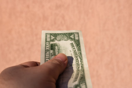 Hand holding a dollar banknote, showing paper texture