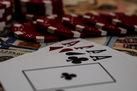 Stack of poker chips over american dollar bills and playing cards representing casino gambling and...