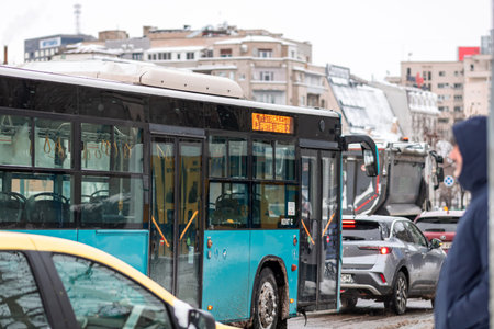 Winter morning commute with public transport STB vehicle on snowy roads in Bucharest Romaniaのeditorial素材