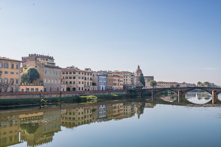 Famous historic bridge and old buildings along the Arno river in Florence Italyの写真素材