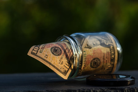 US dollar banknote saving money in glass jar. Consumption and economy. Business, tips, finance, saving, banking and people concept