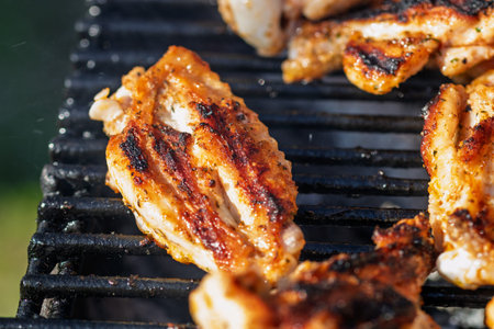 Pork and chicken steak grilling on charcoal barbecue with open flames outdoor cooking scene