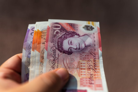 A closeup shot of a woman's hand holding a banknote
