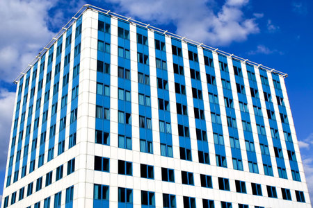 Modern blue office building corner and bright sky