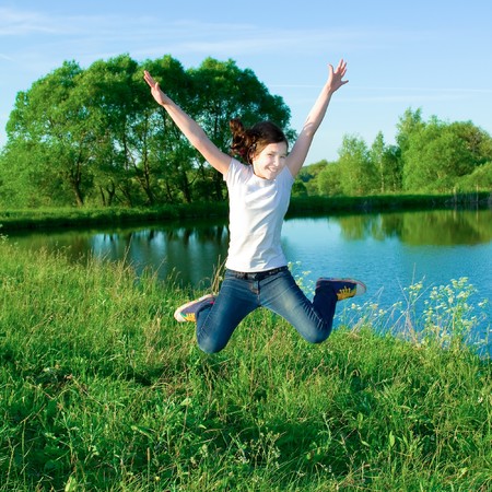 smiling jumping girl with open handsの写真素材