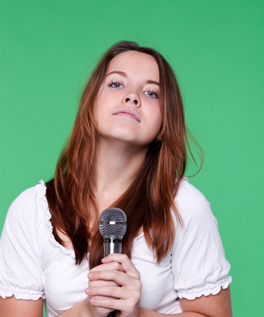 portrait of beautiful singer girl with microphone in handの写真素材
