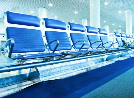 Business and transportation background of contemporary blue spacious hallway of airport, waiting room with seatsの写真素材