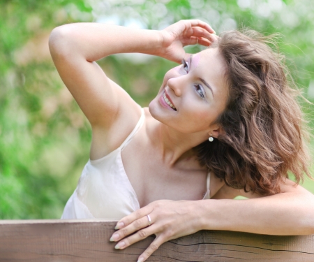 closeup portrait of pretty tender beautiful young female face with clear skin and delicate complexion in the summer evening sunshine in natureの写真素材