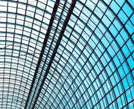 underside wide angled and perspective view to steel blue glass airport ceiling through high rise building skyscrapers, business concept of successful industrial architectureの写真素材