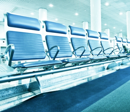 Business and transportation background of contemporary blue spacious hallway of airport, waiting room with seatsの写真素材