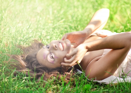 closeup portrait of pretty tender beautiful young female face with clear skin and delicate complexion in the summer evening sunshine in natureの写真素材